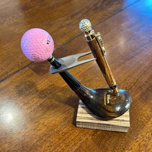 Golfer&#39;s pen on classic wood club and base