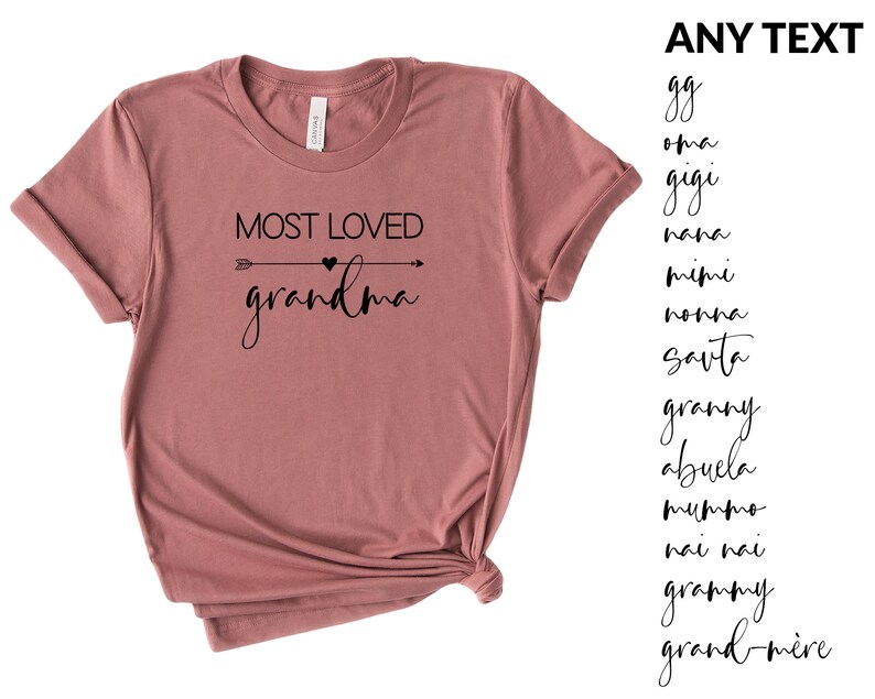 May include: A mauve t-shirt with the text "MOST LOVED grandma" in black lettering with an arrow and heart graphic. The text "ANY TEXT" is listed on the right side of the image with a list of different names for grandmother in black lettering.