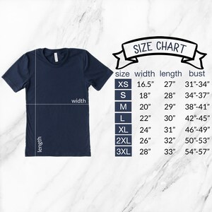 May include: A size chart for a t-shirt, showing the width, length, and bust measurements for sizes XS to 3XL. The chart is displayed next to a navy blue t-shirt.