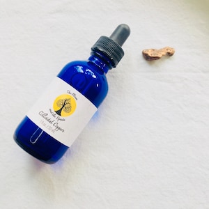 Könnte beinhalten: Eine blaue Glasflasche mit Tropfer, beschriftet mit "The Moon and the Spade Colloidal Copper 1 fl. oz. / 30 ml."