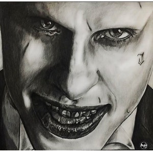 Puede incluir: Un dibujo a lápiz en blanco y negro del Joker de la película Escuadrón Suicida. El Joker se muestra con una sonrisa siniestra y un tatuaje en la mejilla que dice "Damaged".