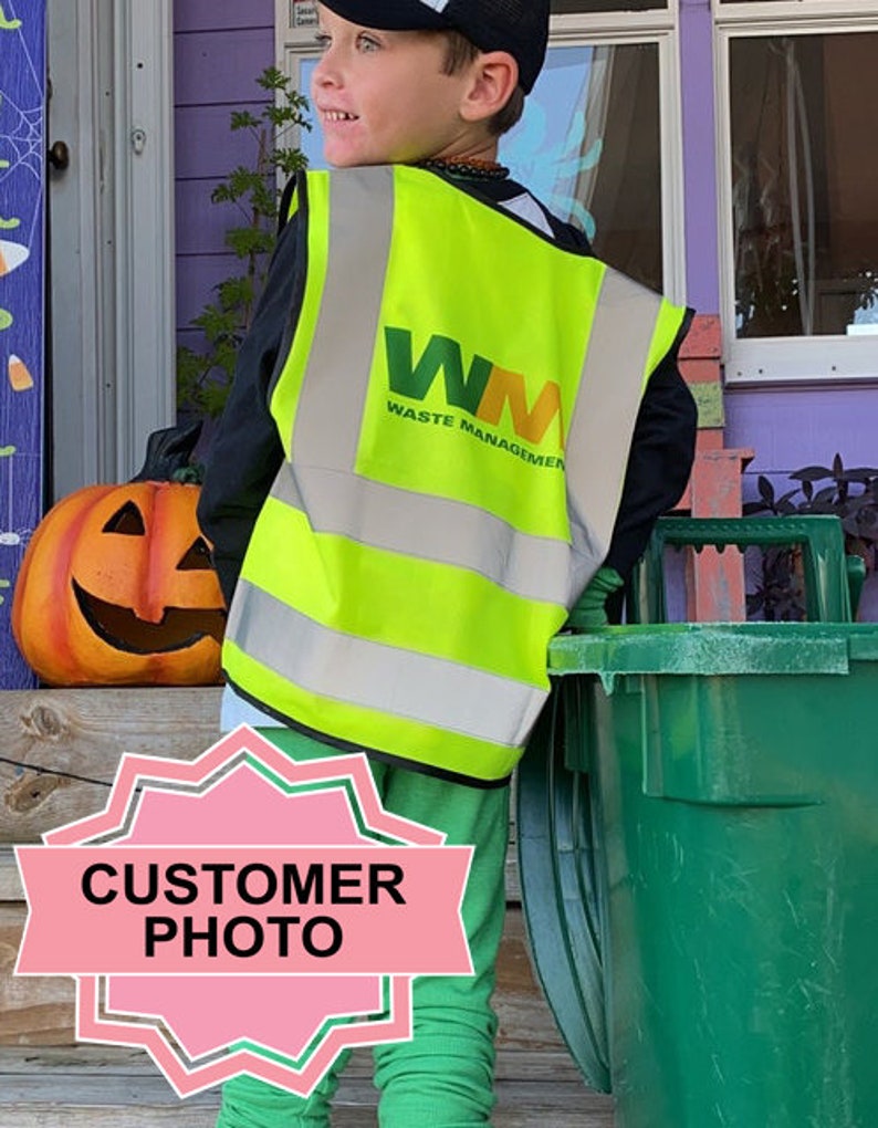 Peut inclure: Un jeune portant un gilet de s&eacute;curit&eacute; jaune et vert avec le logo "WM Waste Management" tient une poubelle de recyclage verte. La personne porte une chemise noire et un pantalon vert.
