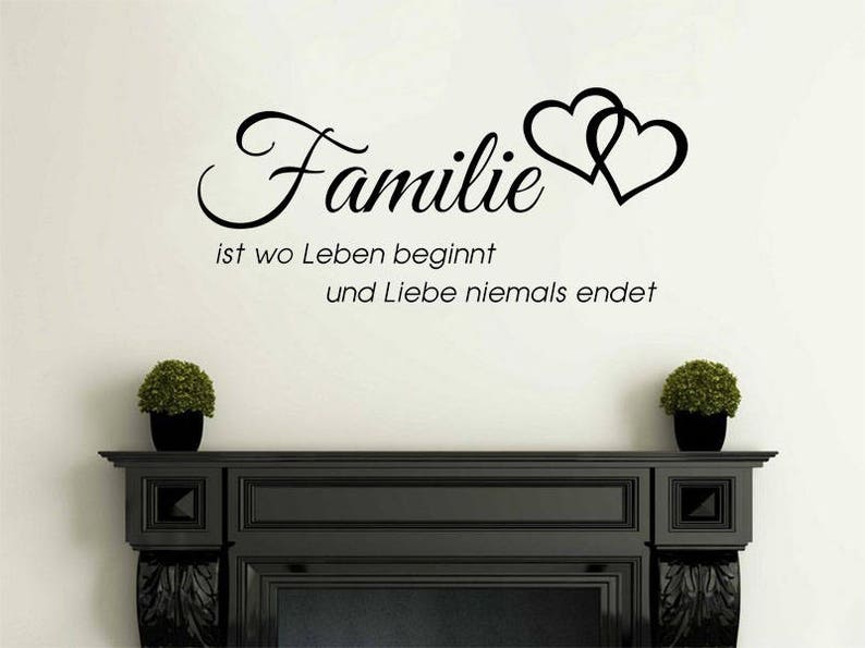 Puede incluir: Pegatina de pared en blanco y negro con el texto "Familie ist wo Leben beginnt und Liebe niemals endet" y dos corazones entrelazados.