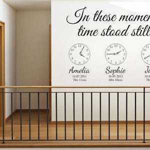 Może przedstawiać: Biała ściana z czarnym tekstem, który brzmi "In these moments, time stood still..." oraz trzy czarno-białe naklejki z zegarami z nazwami Amelia, Sophie i Jack, ich datami urodzenia i wagą w funtach i uncjach.