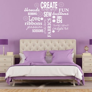 May include: A purple bedroom with a white headboard and a white nightstand. The wall has a white vinyl decal with the words "CREATE", "THREADS", "BOBBINS", "SEW", "BUTTONS", "LOVE", "RIBBONS", "PASSION", "SCISSORS", "FABRICS", "FUN", "SEW", and "INSPIRE".