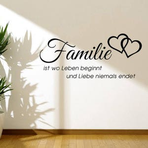 Puede incluir: Pegatina de pared en blanco y negro con el texto "Familie ist wo Leben beginnt und Liebe niemals endet" y dos corazones entrelazados.