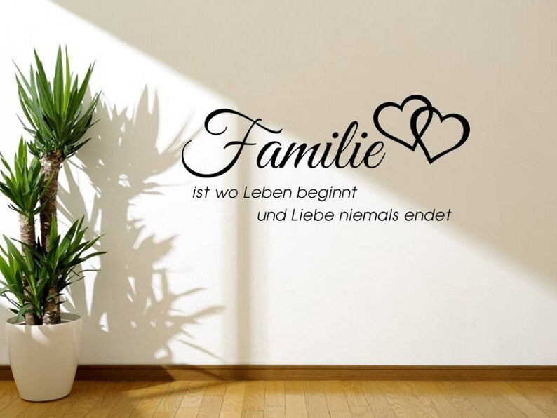 Puede incluir: Pegatina de pared en blanco y negro con el texto "Familie ist wo Leben beginnt und Liebe niemals endet" y dos corazones entrelazados.