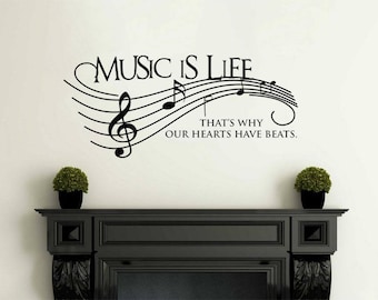 Op de afbeelding: Zwart-witte wanddecoratie met muzieknoten en de tekst "Music is Life. That's why our hearts have beats."