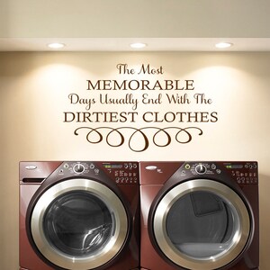 Könnte beinhalten: Ein brauner Wandaufkleber für die Waschküche mit dem Text "The Most MEMORABLE Days Usually End With The DIRTIEST CLOTHES" und einer dekorativen Verzierung unter dem Text.