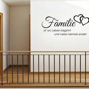 Puede incluir: Pegatina de pared en blanco y negro con el texto "Familie ist wo Leben beginnt und Liebe niemals endet" y dos corazones estilizados.