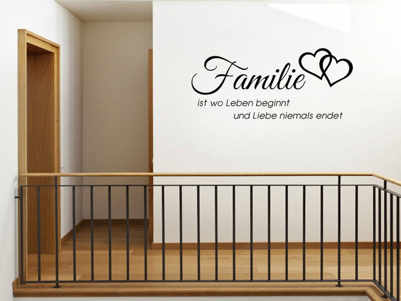 Puede incluir: Pegatina de pared en blanco y negro con el texto "Familie ist wo Leben beginnt und Liebe niemals endet" y dos corazones estilizados.