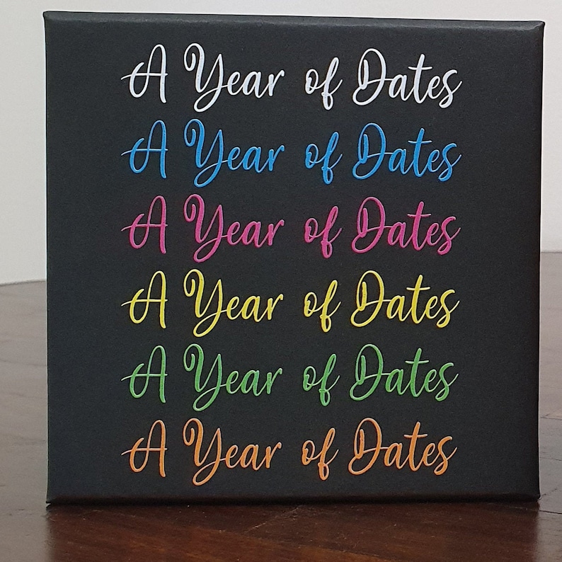 K&ouml;nnte beinhalten: Eine schwarze Leinwand mit dem Text "A Year of Dates", der sechsmal in verschiedenen Farben wiederholt wird: Wei&szlig;, Blau, Rosa, Gelb, Gr&uuml;n und Orange.