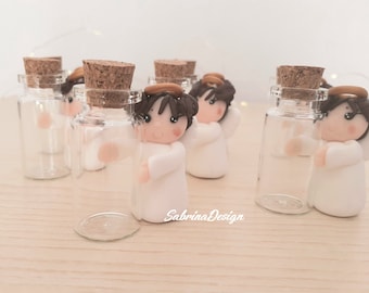 Könnte beinhalten: Ein Set mit sechs kleinen Glasflaschen mit Korkstopfen, jede mit einer weißen Porzellanengelfigur mit braunen Haaren und einem goldenen Heiligenschein. Die Flaschen sind klar und die Engel sind alle in die gleiche Richtung gewandt.