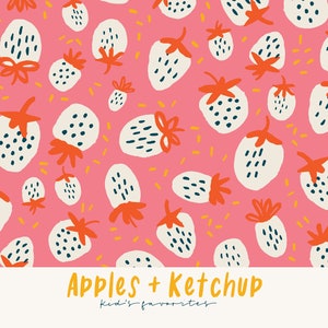 Op de afbeelding: Een roze achtergrond is bedekt met een patroon van witte aardbeien met oranje stelen en groene bladeren. De aardbeien hebben zwarte zaden. De tekst "Apples + Ketchup" en "kid's favorites" staat onderaan.