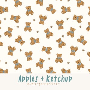 Op de afbeelding: Een herhalend patroon van bruine teddyberen met blauwe strikken en kleine bijenillustraties op een crèmekleurige achtergrond. De tekst "Apples + Ketchup" en "Kid's favorites" staat onderaan de afbeelding.