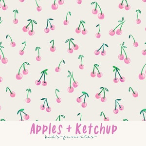 Op de afbeelding: Een herhalend patroon van roze kersen met groene stelen en bladeren op een crèmekleurige achtergrond. De tekst "Apples + Ketchup" en "Kid's favorites" staat onderaan de afbeelding.