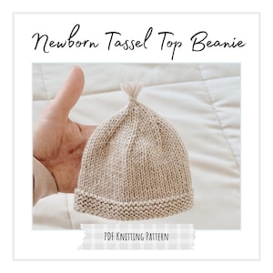 May include: A beige newborn tassel top beanie. The knitted hat has a ribbed brim and a tassel at the top. The text "Newborn Tassel Top Beanie" is at the top of the image. The text "PDF Knitting Pattern" is at the bottom.