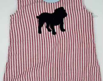 May include: Red and white striped baby romper with a black bulldog applique. The romper has button closures on the shoulders and snaps at the legs. A blue tag with the text "Gingham & Pearls est. 2016" is attached.