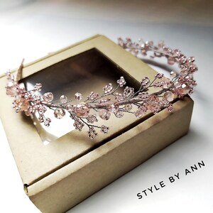 May include: A delicate pink beaded headband with a floral design. The headband is made with small, iridescent beads and wire, creating a delicate and feminine look. The headband is perfect for adding a touch of sparkle to any outfit.