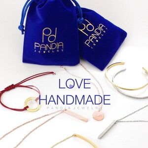 May include: A collection of handmade jewelry pieces, including necklaces, bracelets, and a bangle. The jewelry is made of gold, silver, and red string. The jewelry is displayed on a white background with two blue velvet bags with the text "PD PANDIA JEWELRY" printed on them. The text "LOVE HANDMADE PANDIA JEWELRY" is displayed in the center of the image.