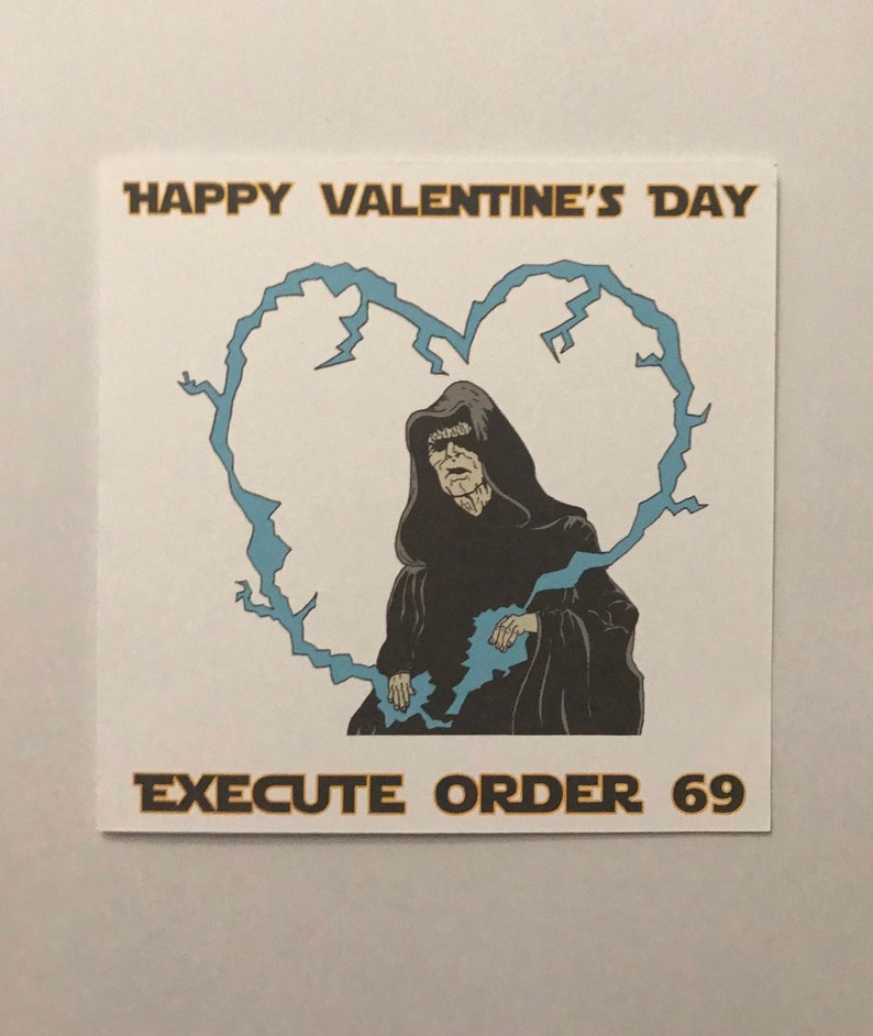 May include: Square white card with a cartoon image of a character in a black hooded robe inside a blue lightning bolt heart. The text "HAPPY VALENTINE'S DAY" is above the heart, and "EXECUTE ORDER 69" is below.