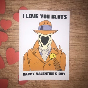 Könnte beinhalten: Valentinstagskarte mit einer Comicfigur in einem beigen Mantel und Hut, mit einer schwarz-weißen Maske. Die Karte lautet "I LOVE YOU BLOTS" und "HAPPY VALENTINE'S DAY."