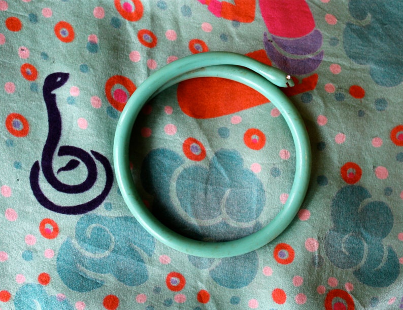 20s plastic turquoise serpent bangle with rhinestone eyes and carved happy smile 1920s celluloid smiling snake bracelet