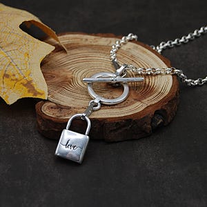 Verzilverde hangslotketting: antieke rolo-ketting knevelsluiting