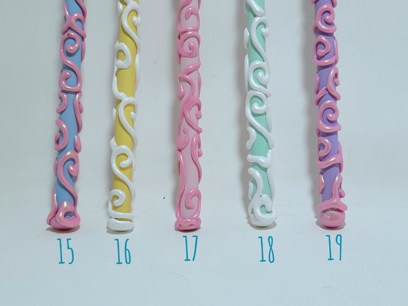 May include: Five decorative wands in various colours, including blue, yellow, pink, mint green, and purple, with white and pink swirl designs. Each wand is numbered 15-19. These wands are likely for fantasy or cosplay.