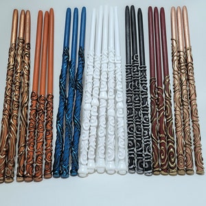 May include: A selection of decorative wands in various colours, including copper, orange, blue, white, black, and burgundy. Each wand features intricate, swirling designs and is approximately 30 cm long.