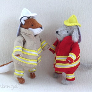 In this picture: two handmade felt toy animals, fox and dog, both dressed as a firefighter, one in a red costume, the other in a sand-colored costume. All clothing has refelcting stripes in yellow and silver. The dog with the red costume wears a yellow helmet, the other has a white helmet. All is made with a PDF handsewing pattern from WoolFeltWonders, part of a series with toy animal and clothing patterns to mix and match, to portray hobby or profession for play.