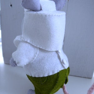 In this picture: a handmade felt mouse dressed as a beekeeper, with white jacket, and bee hood. All this is is made with PDF hand sewing pattern from WoolFeltWonders by Tintangel and is part of a series with felt toy animals and all kinds of clothing sets to mix and match to portray hobby or profession. Easy to make animals and clothing sets for decoration and play.