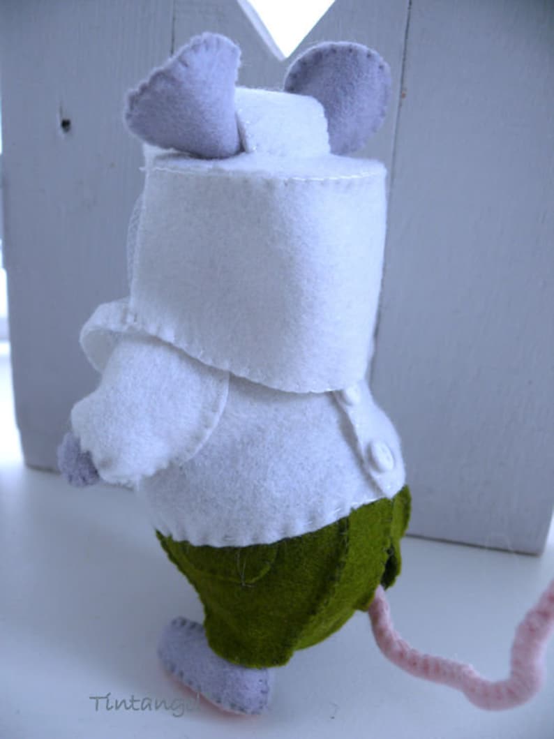 In this picture: a handmade felt mouse dressed as a beekeeper, with white jacket, and bee hood. All this is is made with PDF hand sewing pattern from WoolFeltWonders by Tintangel and is part of a series with felt toy animals and all kinds of clothing sets to mix and match to portray hobby or profession. Easy to make animals and clothing sets for decoration and play.