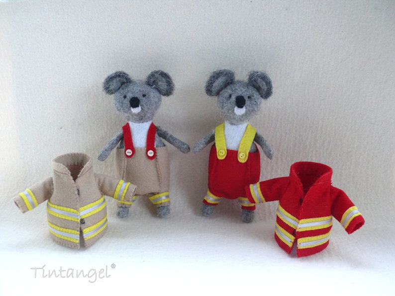 In this picture: two handmade felt koala bears, both dressed as a firefighter, one in a red costume, the other in a sand-colored costume. all clothing has refelcting stripes in yellow and silver.  All is made with a PDF handsewing pattern from WoolFeltWonders, part of a series with toy animal and clothing patterns to mix and match, to portray hobby or profession for play.