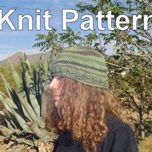 Pode incluir: Uma pessoa usando um chapéu de tricô listrado verde e marrom com cabelo longo e encaracolado. O chapéu é um design simples com uma aba larga. A pessoa está em pé na frente de uma grande planta de agave e uma árvore. O texto "Knit Pattern" está escrito em letras brancas sobre um fundo de céu azul.
