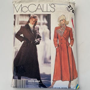 May include: A McCall's 2768 sewing pattern envelope featuring illustrations of a long, double-breasted coat. The package displays a photograph of a person in a dark textured coat and a drawing of a person in a rust-colored coat with a beret and scarf.