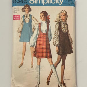 Puede incluir: Un sobre de patrón de costura Simplicity 8345 para talla 14, busto 36. La ilustración muestra tres variaciones de un vestido sin mangas usado sobre blusas de manga larga, incluyendo una versión azul, una roja a cuadros y una marrón oscuro.