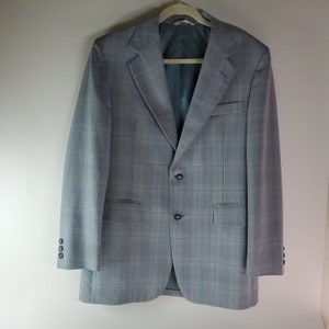May include: A gray plaid blazer with a single button closure. The blazer has a notched lapel and two flap pockets.