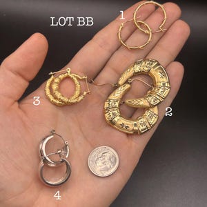 May include: A collection of gold and silver hoop earrings. The earrings vary in design, including bamboo-style, textured, and simple round hoops. A US dime is included for size reference. The text "LOT BB" and "white" are visible.