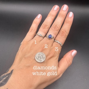 May include: Three white gold rings labeled 1, 2, and 3. Ring 1 features small diamonds, ring 2 has a central blue stone, and ring 3 is a textured band. A US dime is included for scale, with the text diamonds white gold visible below it.