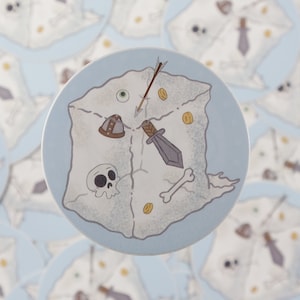 May include: A round sticker with a white background featuring a cartoon illustration of a treasure chest with a skull, a sword, a helmet, an arrow, and gold coins.