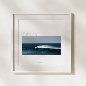 Può includere: Una stampa incorniciata con una fotografia di un'onda alta che si infrange nell'oceano. Il testo "Offshore magic" è scritto sopra l'immagine.