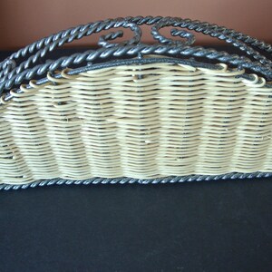 Pu&ograve; includere: Un porta tovaglioli in vimini semicircolare con una cornice in metallo nero. La cornice &egrave; decorata con un motivo a corda.