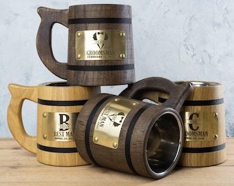 May include: Three wooden beer mugs with personalised engraved brass plates. The mugs are brown with black bands and have a stainless steel interior. The plates have the names "Jason", "Brian", and "Cris" with the titles "Groomman", "Best Man", and "Groomman" and the dates "February 22, 2023", "April 20, 2023", and "April 20, 2023".