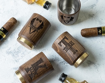 May include: Four personalized wooden whiskey glasses with brass accents. The glasses are engraved with the names "Brandon", "Steven", "Thomas", and "Kevin".