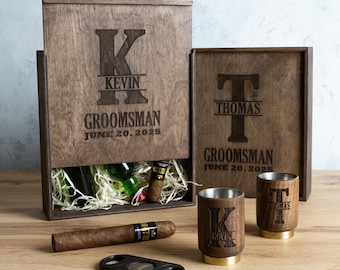 May include: Two wooden boxes with engraved initials and the word "Groomsman" with a date. The boxes contain a cigar, a cigar cutter, and two shot glasses with engraved initials.