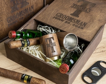 May include: A wooden box with a personalised inscription for a groomsman. The box contains a bottle of spirits, a cigar, a cigar cutter, and a personalised wooden mug. The inscription on the box reads "Groomsman June 20, 2025".