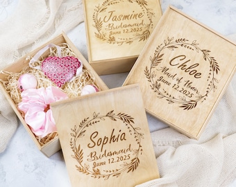 May include: Three wooden boxes with engraved floral wreaths and names. The boxes are labelled "Jasmine Bridesmaid June 12, 2025", "Chloe Maid of Honour June 12, 2025", and "Sophia Bridesmaid June 12, 2025".
