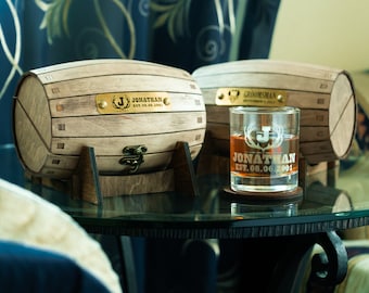 May include: Two small wooden barrels with brass accents and engraved text, one reads "Jonathan Est. 08.06.2001" and the other reads "Groomsman", a glass with the same engraving as the barrel sits on a wooden coaster.