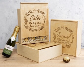 May include: Three wooden gift boxes with engraved floral wreaths and personalised text. The boxes are labelled "Chloe Maid of Honour June 12, 2025", "Jasmine Bridesmaid June 12, 2025", and "Bridesmaid June 12, 2025".
